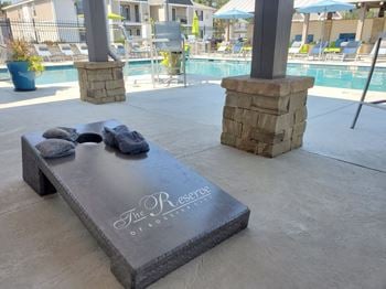 A stone bench with towels on it and a pool in the background